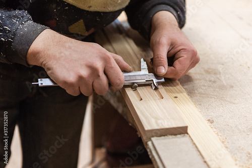 The joiner measures products. Joiner measuring tool at work.