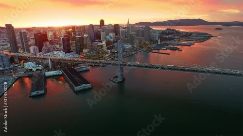Aerial view of the Bay Bridge and San francisco financial district at sunset. California. United States. Night. Shot from helicopter.