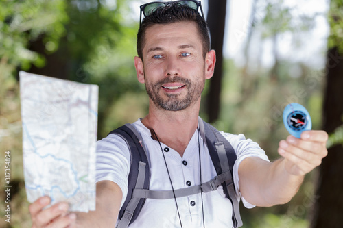 male hiker holding printed manp and compass photo