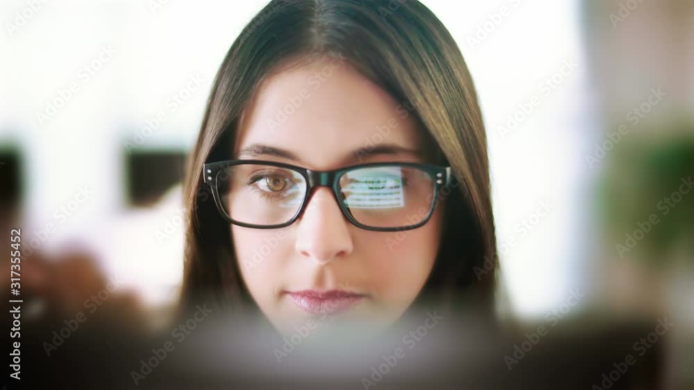 Attractive young woman working in a touchscreen computer or tablet. Businesswoman with glasses in an office space. Technology. Daylight. Dolly shot. Attractive young woman working in a touchscreen computer or tablet. Businesswoman with glasses in an office space. Technology. Daylight. Dolly shot.