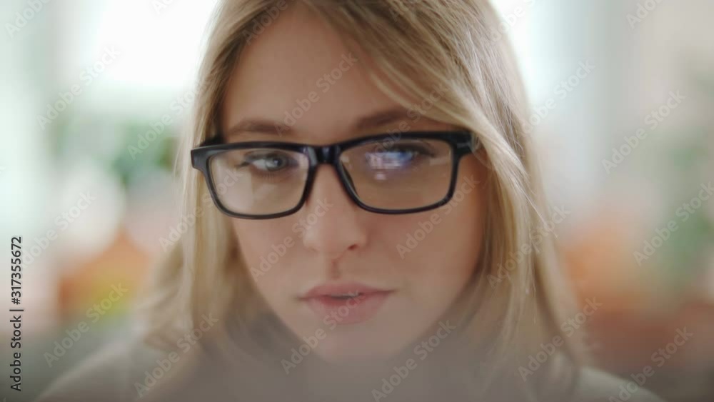 Attractive young woman working in a touchscreen computer or tablet. Businesswoman with glasses in an office space. Technology. Daylight. Dolly shot. Attractive young woman working in a touchscreen computer or tablet. Businesswoman with glasses in an office space. Technology. Daylight. Dolly shot.