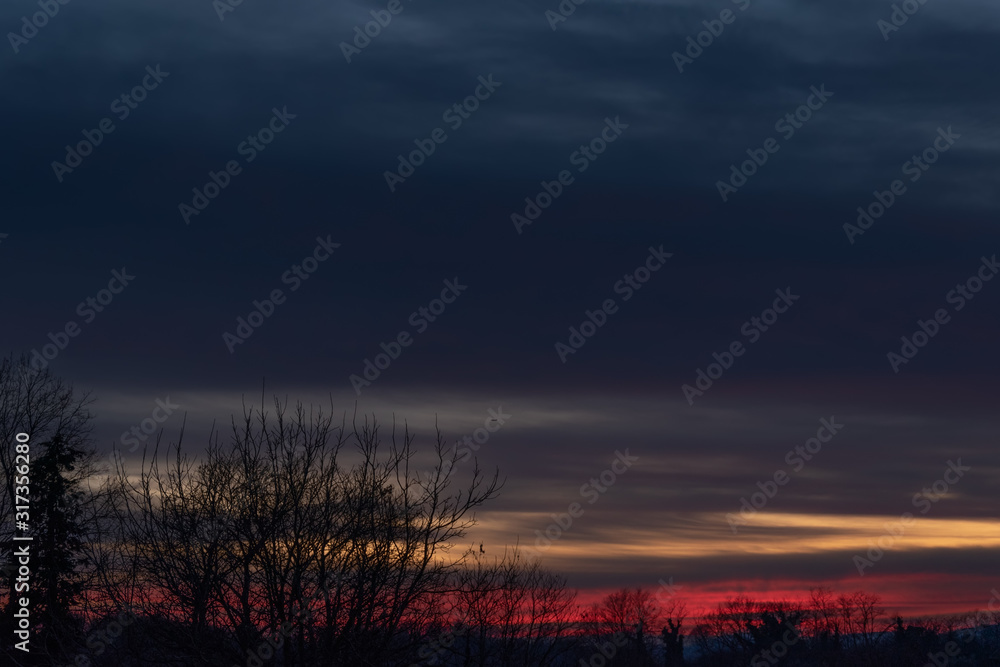 Fototapeta premium Colorful dramatic sky with a cloud at sunset with a plane flying far