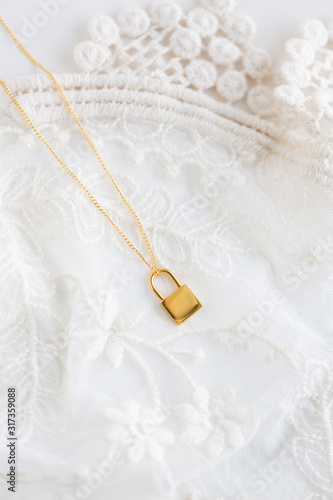 Gold lock necklace on lace