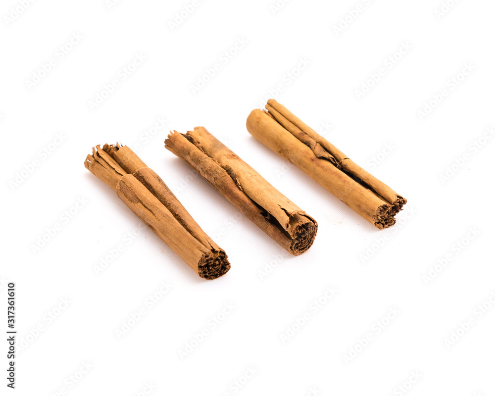 Studio shot three raw dried organic cinnamon sticks isolated on white Studio shot three raw dried organic cinnamon sticks isolated on white