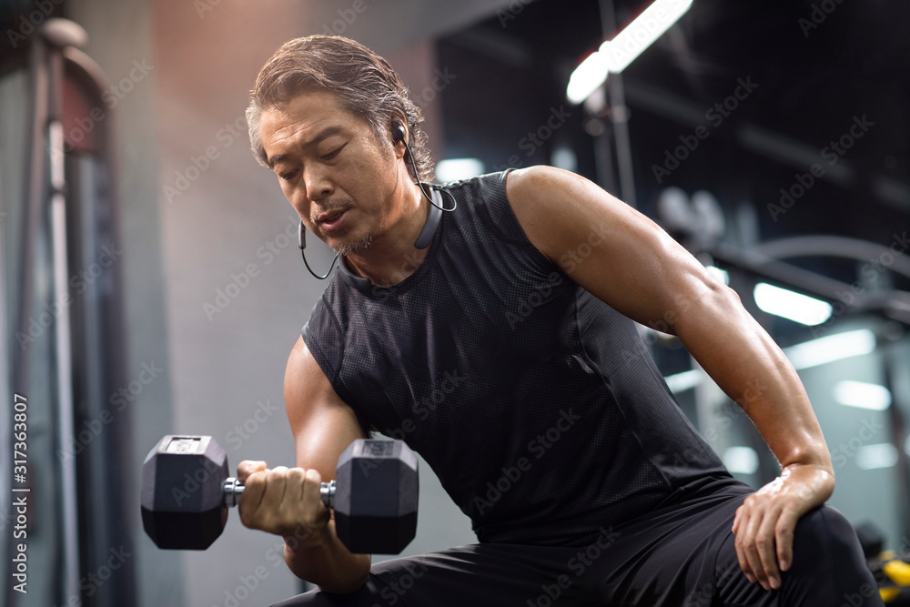 Mature man working out with hand weights at gym Mature man working out with hand weights at gym