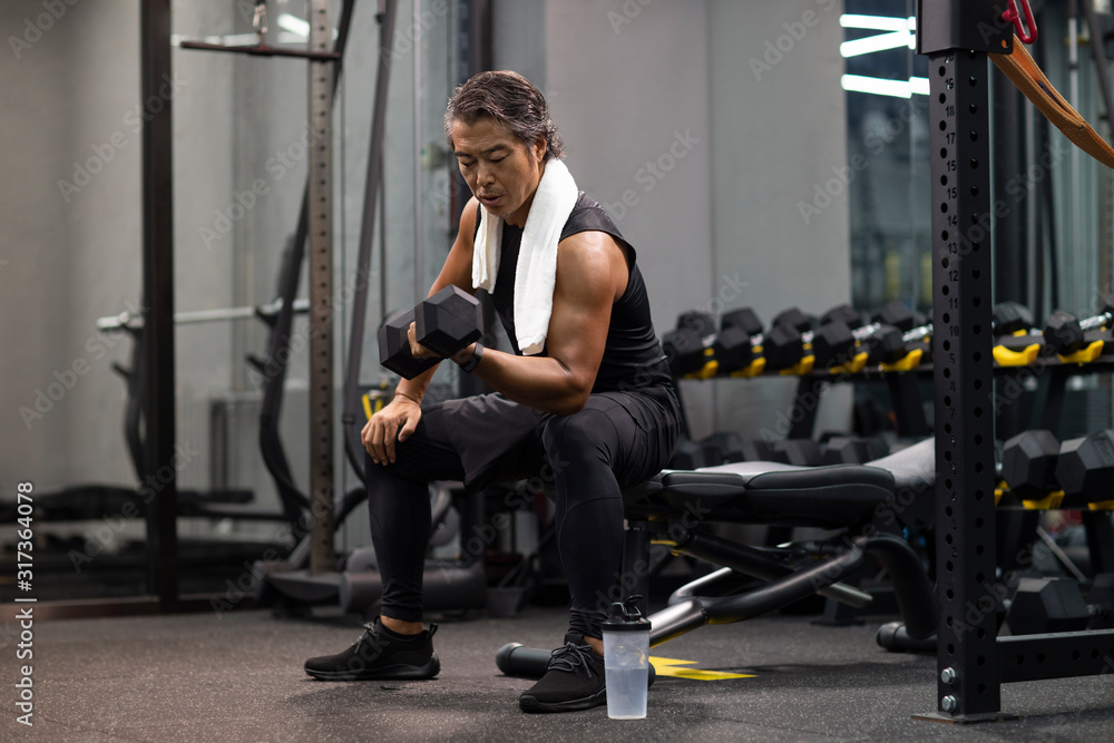 Mature man working out with hand weights at gym Mature man working out with hand weights at gym