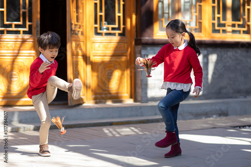 Happy sibling kicking shuttlecock