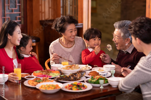 Happy family eating dinner for Chinese New Year photo