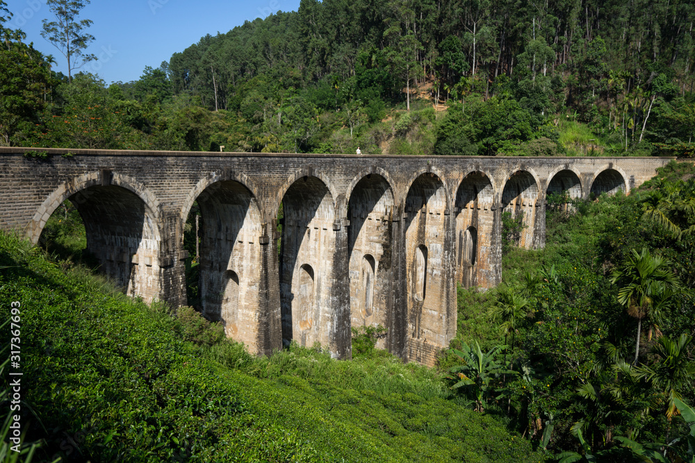 Thoughtful Asian woman walking along railway in old ancient bridge Thoughtful Asian woman walking along railway in old ancient bridge