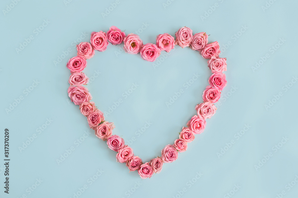 Beautiful heart made of beautiful pink roses on a blue background. I love you. Greeting card