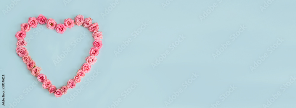 Beautiful heart made of beautiful pink roses on a blue background. I love you. Greeting card