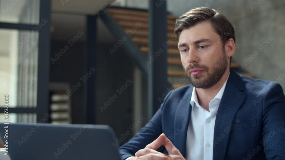 Closeup focused businessman talking on laptop camera at remote office. Closeup focused businessman talking on laptop camera at remote office.