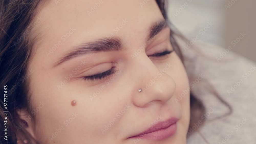 Professional master eyebrow woman combing eyebrows to client in a beauty salon. Professional master eyebrow woman combing eyebrows to client in a beauty salon.