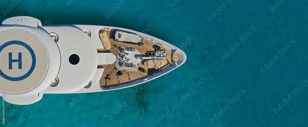 Fototapeta Aerial drone ultra wide photo of mega yacht nose docked in tropical exotic island bay with turquoise clear sea