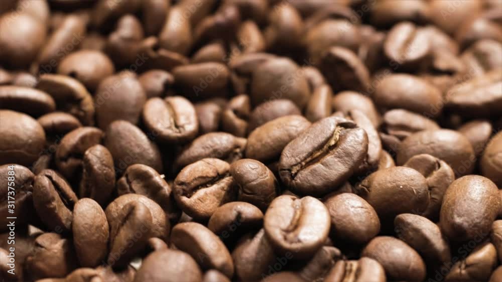 Detail of rotating heap of dark coffee beans Detail of rotating heap of dark coffee beans