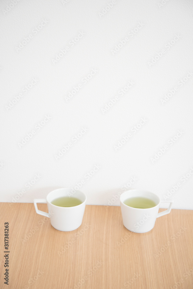 白い2つのマグカップと緑茶 白い2つのマグカップと緑茶