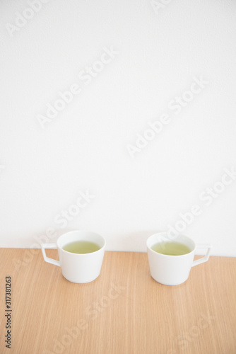 白い２つのマグカップと緑茶