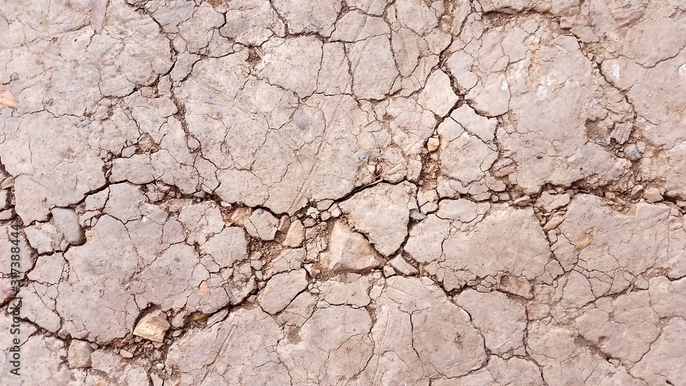 Fototapeta premium Dried soil or close-up arid land. Images of soil during drought background. Hard shadows and damaged ground from above. Royalty free stock images.