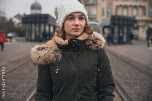 Young woman with winter clothes walking through the city