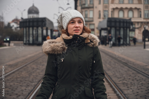 Young woman with winter clothes walking through the city