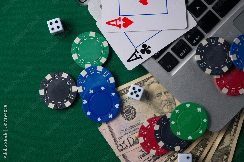 Fototapeta premium Gaming onlan business, online casino or casino. Green gaming table, laptop, money and chips. Game concept for design.
