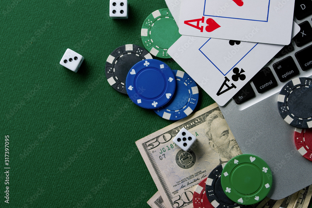 Fototapeta premium Gaming onlan business, online casino or casino. Green gaming table, laptop, money and chips. Game concept for design.