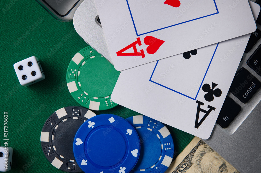 Obraz premium Online casino, poker. Background for business online games, poker, blackjack game. Online card games. Laptop, money and chips.