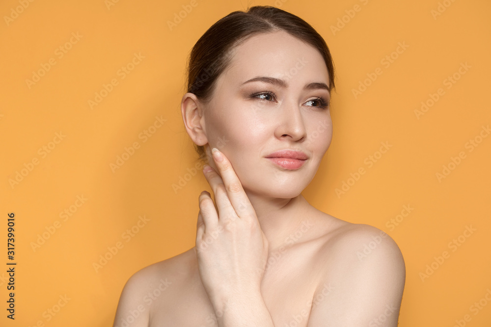 beautiful fashionable woman. Portrait with natural make-up on a green background. hand touches her face beautiful fashionable woman. Portrait with natural make-up on a green background. hand touches her face