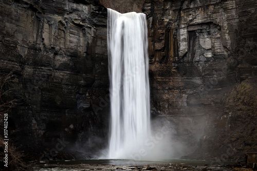 Fototapeta taughannock falls a silky smooth waterfall against a rock face cliff with splash