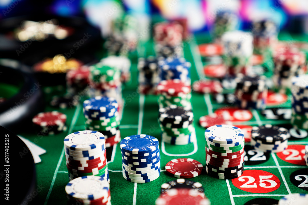 Naklejka premium Casino felt green table with red and black numbers. Stack of poker chips.