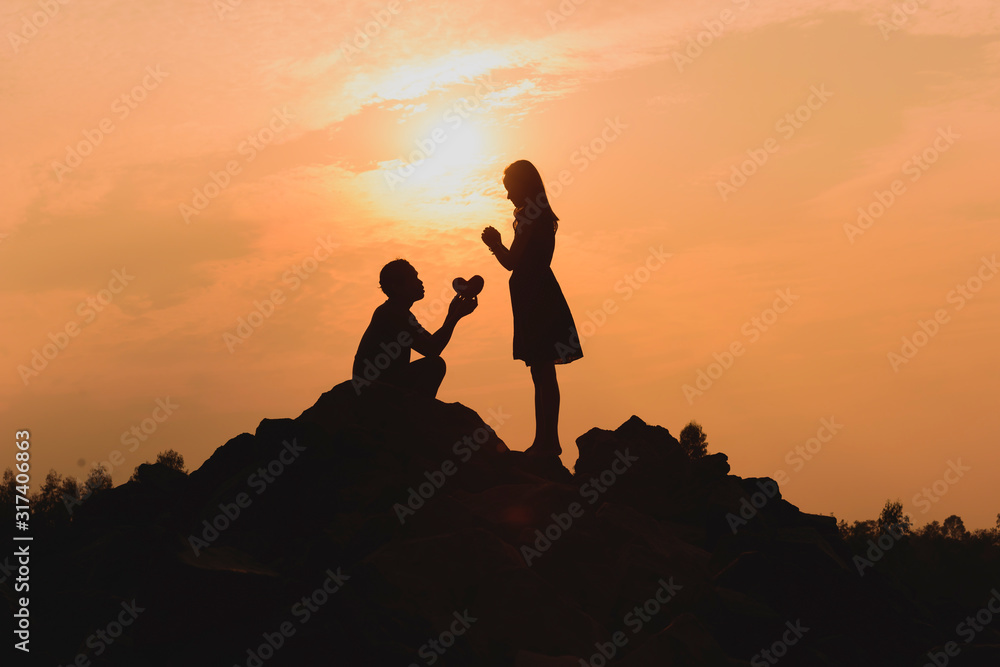 Happy young couple together against beautiful sunset. Freedom, enjoyment concept.