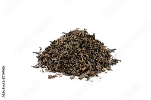 Pile of dry black tea leaves on a white background close-up.