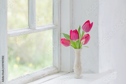 tulips in vase on white windowsill