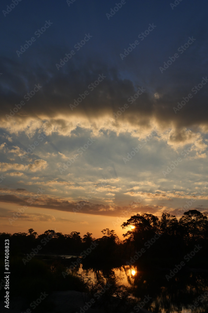 Silhouette of trees on sand beach with beautiful sky reflected on the Mekong River at sunset, The horizon began to turn gold color at night , Fluffy cloud formations in Stung Treng, Cambodia Silhouette of trees on sand beach with beautiful sky reflected on the Mekong River at sunset, The horizon began to turn gold color at night , Fluffy cloud formations in Stung Treng, Cambodia