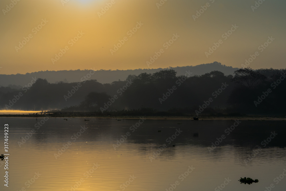 Sunrising over the lake with reflection mist on the water, Landscape sunrise concept