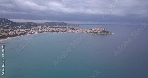 Drone flying at high altitude in the golf of Calvi going towards the city. photo