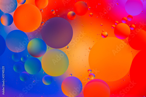 bright oily drops in water with colorful background  close-up 