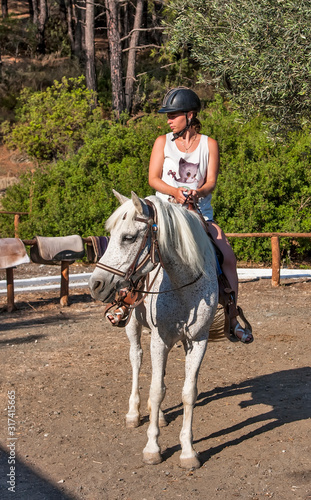 rider in a helmet riding a white horse