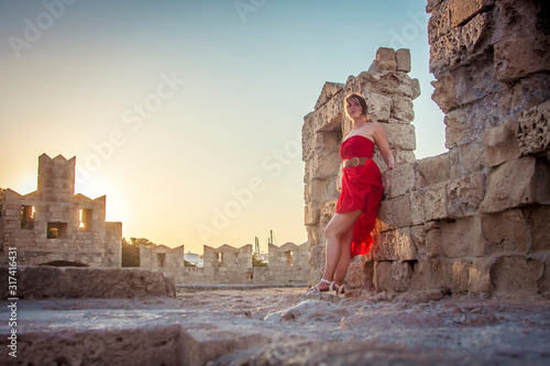 girl in a red dress posing at sunset