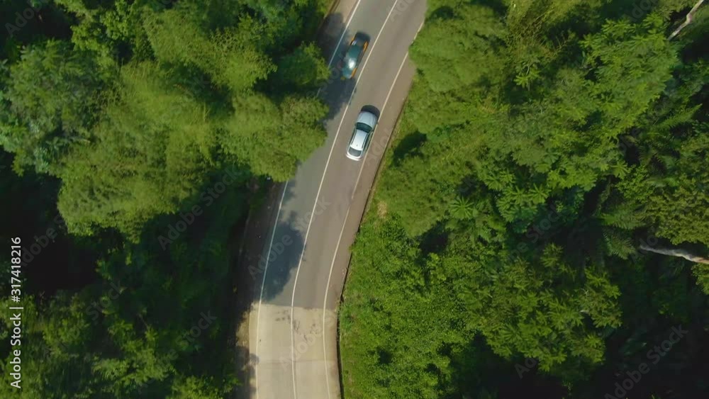 Birds eye view of car on curve road up the hill Birds eye view of car on curve road up the hill