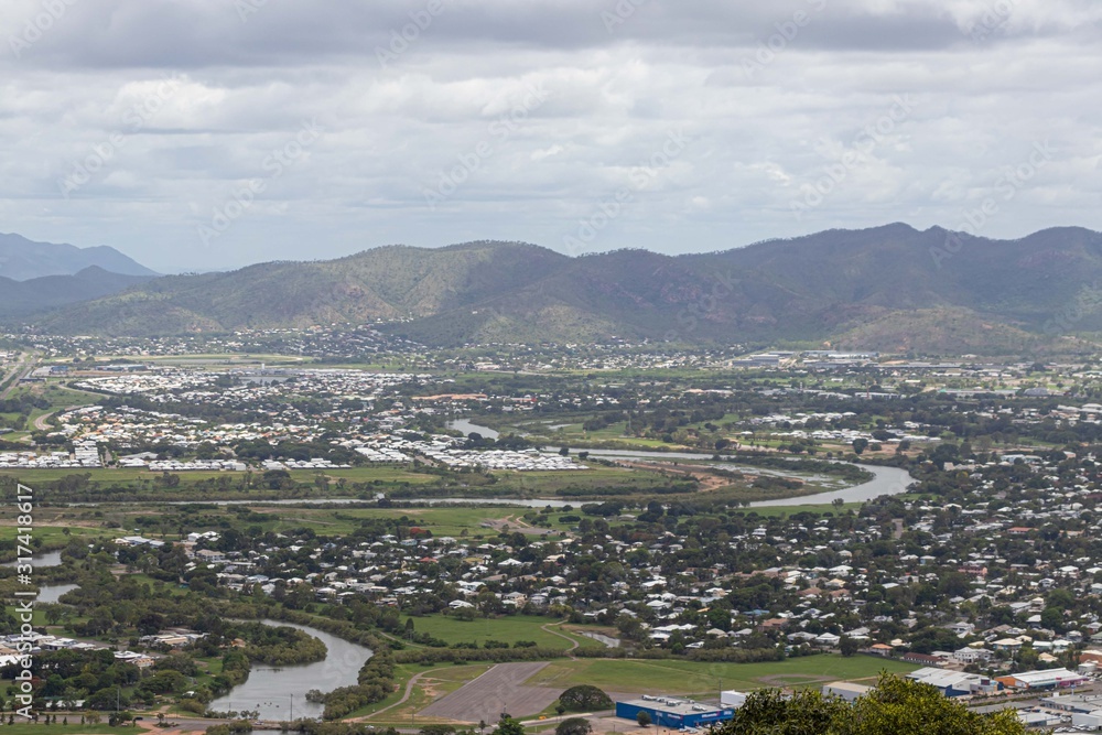 City seen from the top of the lookout with a crystal clear sea and the city in a perfect square with lots of vegetation and mountains. Townsview