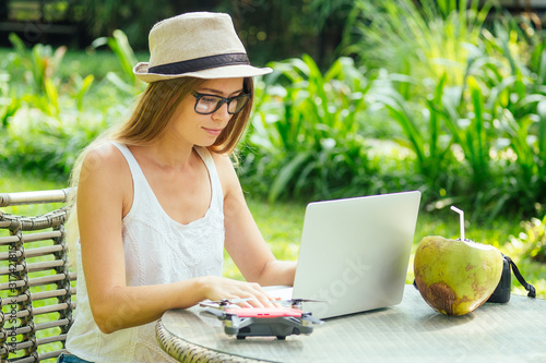 Photography photographer blonde female working outdoor retoucher and drinking coconut