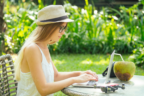 Photography photographer blonde female working outdoor retoucher and drinking coconut