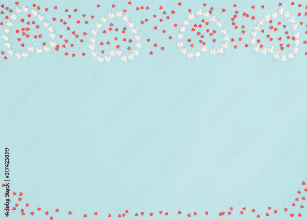 Four hearts made of small pearl hearts on blue background with lots of small red hearts. Valentine's Day, wedding, love, happiness concept. Greeting or invitation card. Flat lay style with copy space. Four hearts made of small pearl hearts on blue background with lots of small red hearts. Valentine's Day, wedding, love, happiness concept. Greeting or invitation card. Flat lay style with copy space.