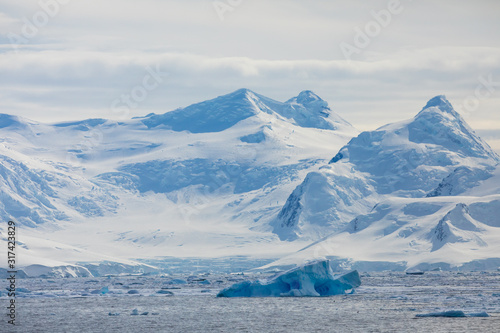 Snow and ice on the mountains near the water in Antarctica, a pristine remote landscape