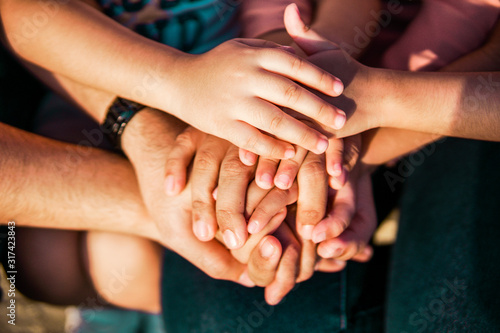 Close up join hands of a family member. A father, mother, daughter and son.