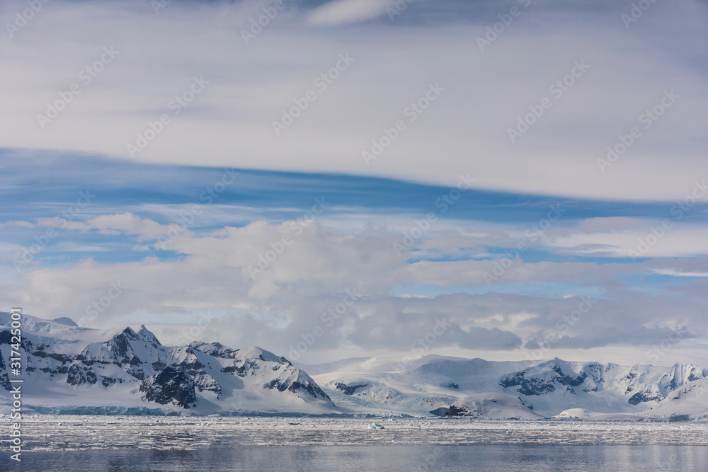 Snow and ice on the mountains near the water in Antarctica, a pristine remote landscape