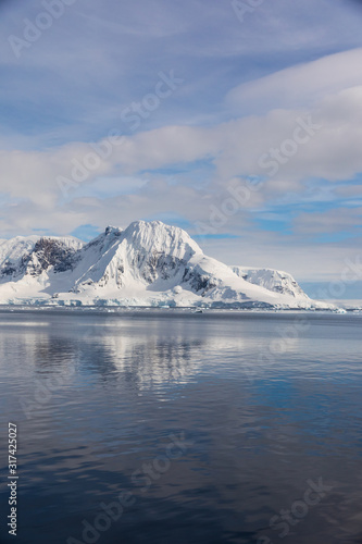Snow and ice on the mountains near the water in Antarctica, a pristine remote landscape