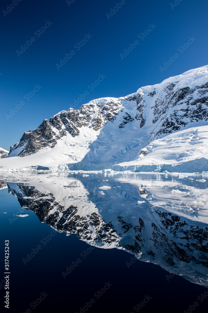 Snow and ice on the mountains near the water in Antarctica, a pristine remote landscape