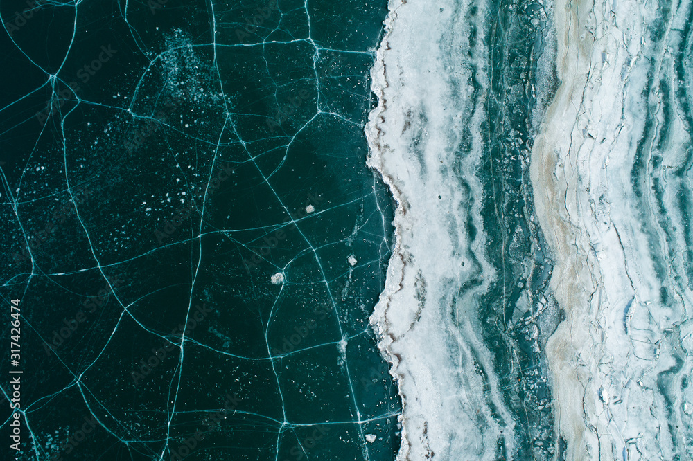 Naklejka premium Ice On Reservoir Shore With Cracks, Top View